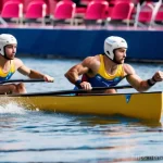 Home 11 몰도바 올림픽 참가 역사 - On the left side, two male athletes, Nicolae Juravschi and Victor Reneysky, are seen in a sleek, mod...